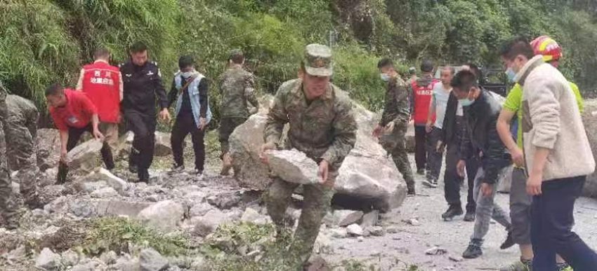 搬開落石清理道路。四川省軍區(qū)供圖