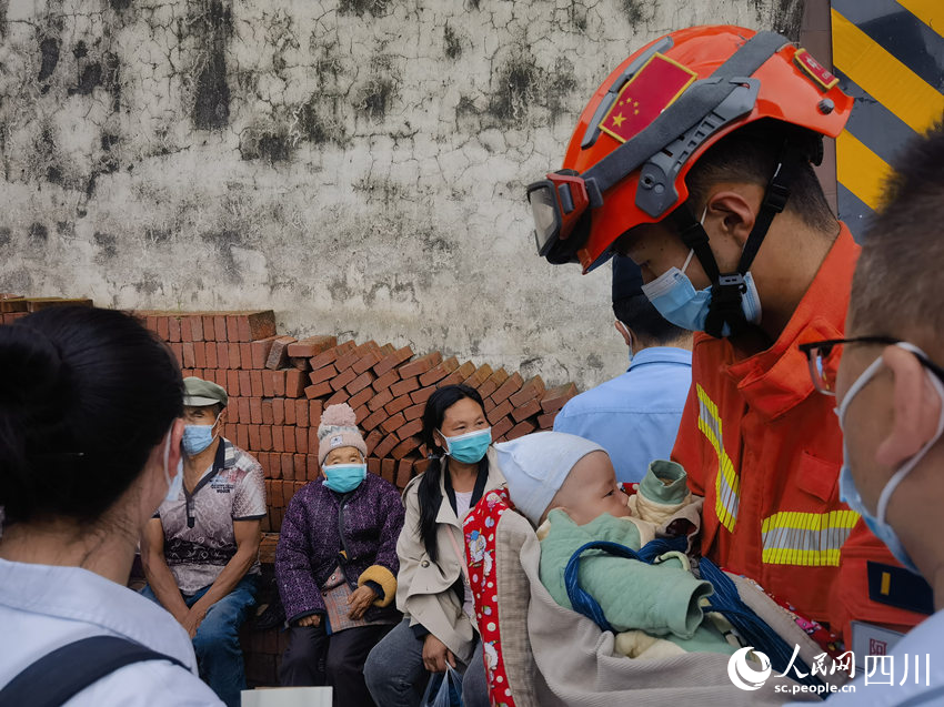 寶寶安靜地在森林消防員懷里。彭科攝