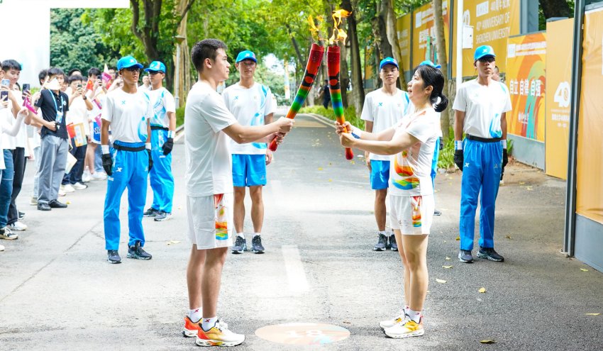 火炬手正在傳遞交接。成都大運(yùn)會執(zhí)委會供圖