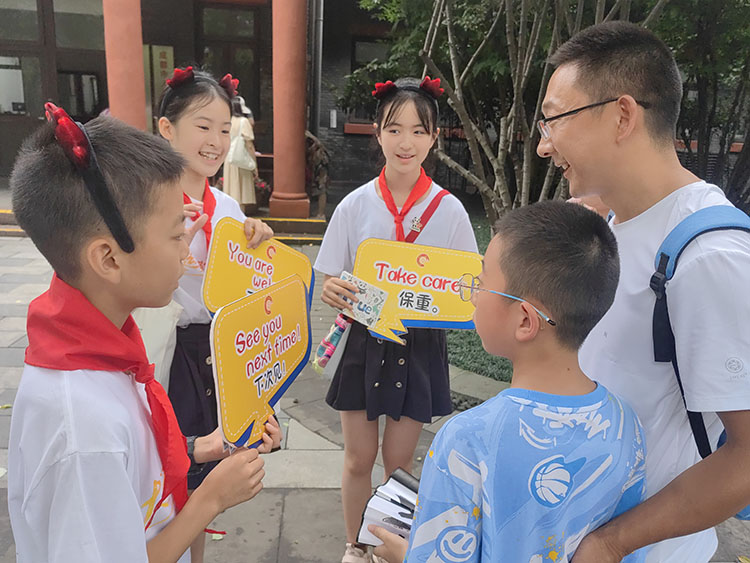 來自青羊的小學生向游客介紹日常用雙語。青羊區(qū)教育局供圖