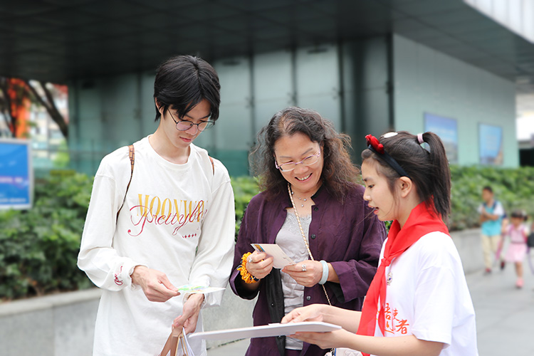 來自青羊的小學(xué)生向游客送上寫有祝福語的明信片。青羊區(qū)教育局供圖