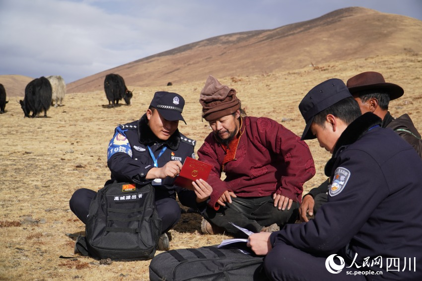 民警為牧民洛絨扎西送來(lái)補(bǔ)辦好的戶口本。人民網(wǎng) 趙祖樂(lè)攝